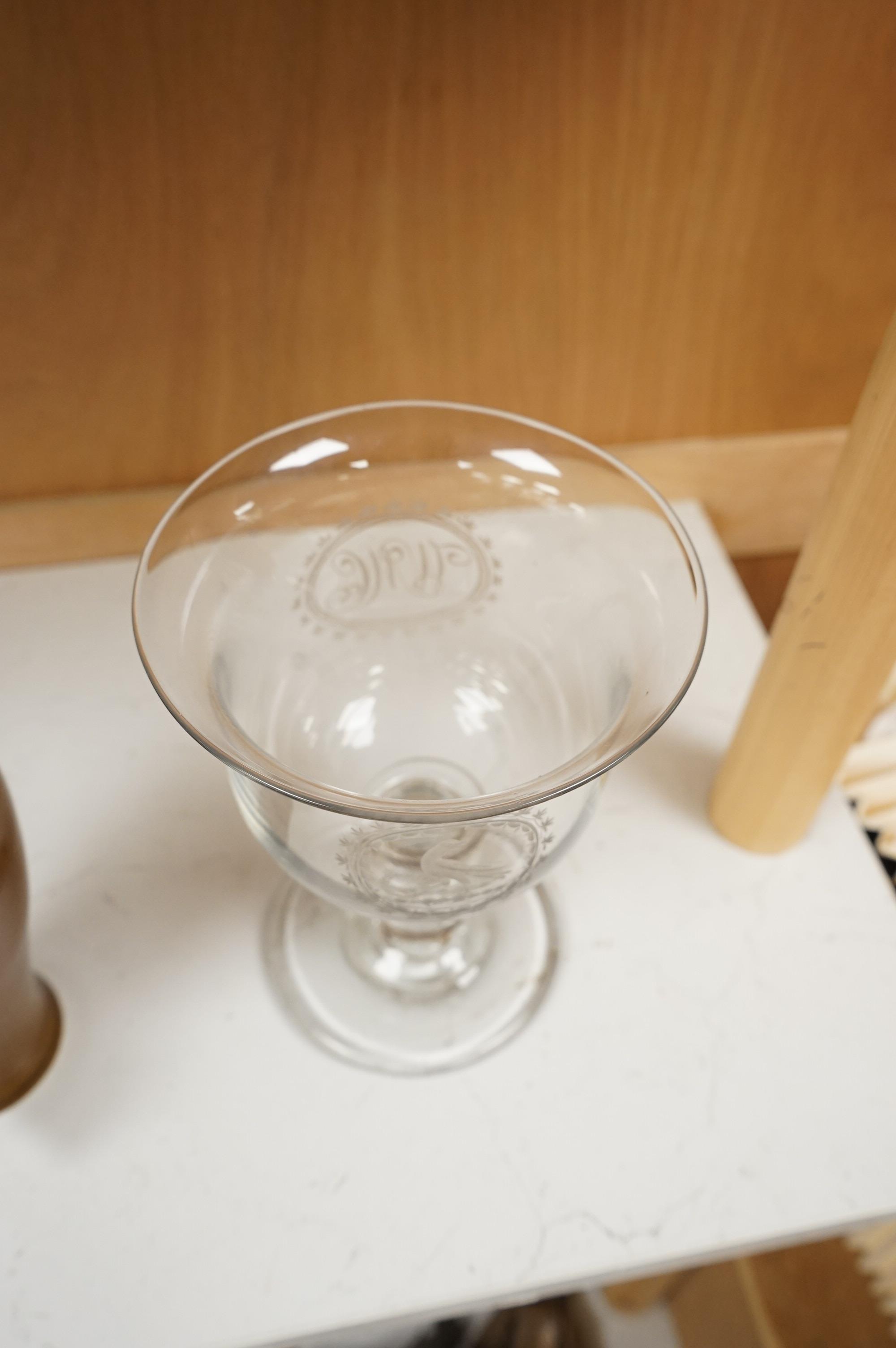 A large George III glass goblet, with inset coins to the hollow ball knopped stem, engraved with a parrot and the initials WMC, 20cm high